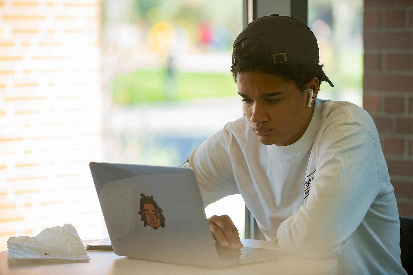 student on a laptop next to a window