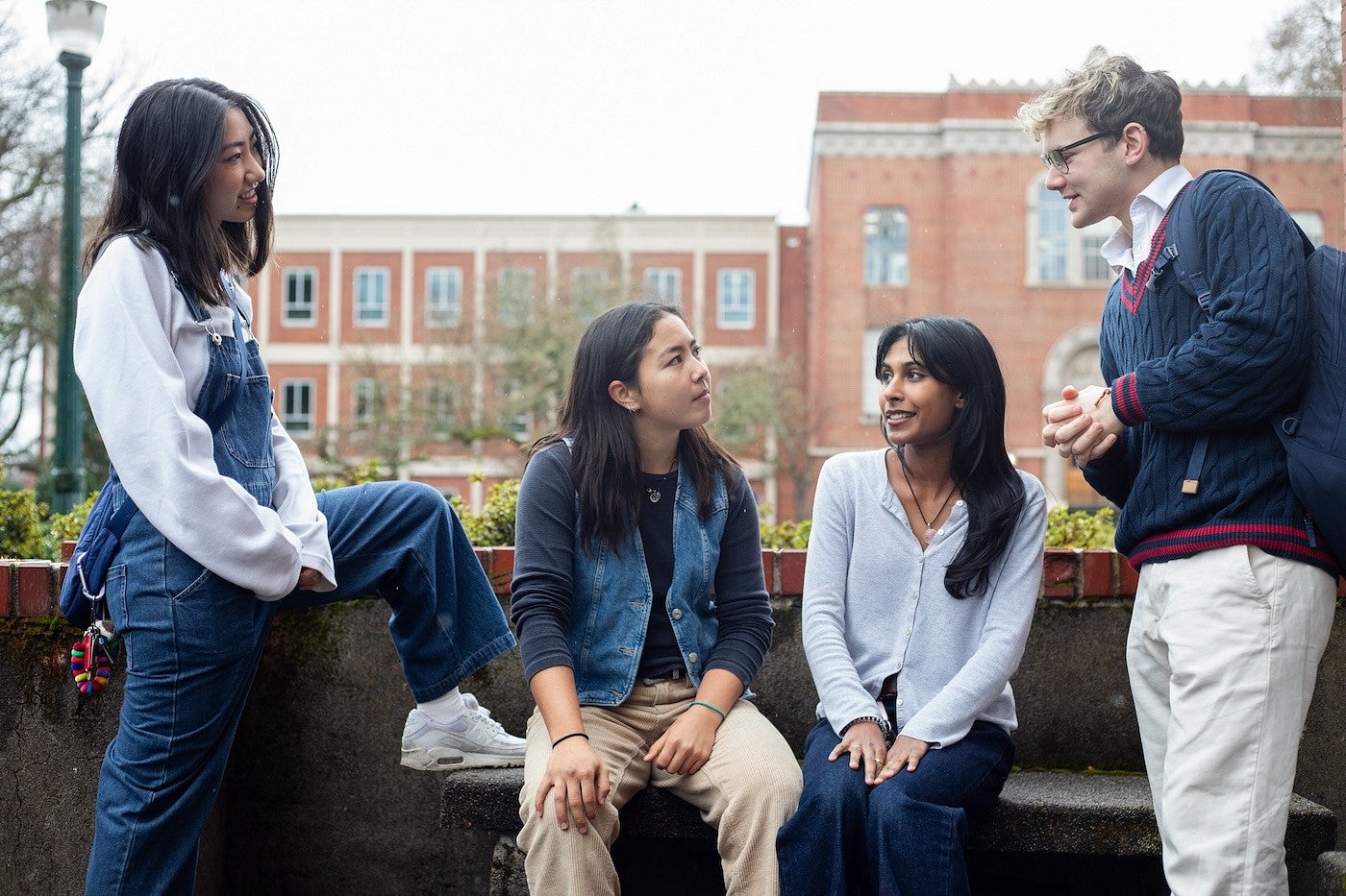 group of students seated on bench outside Chapman hall, talking