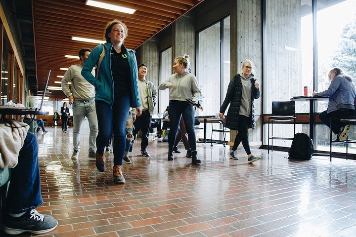 students on forensics team walking down a hallway, smiling and talking