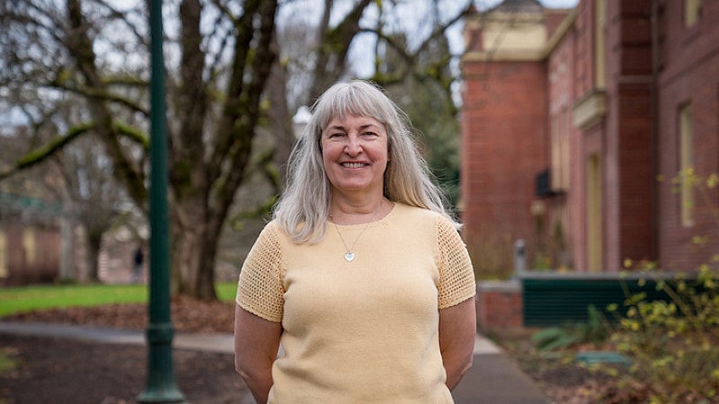 Lisa Wolverton standing outside Chapman Hall on an early spring day.