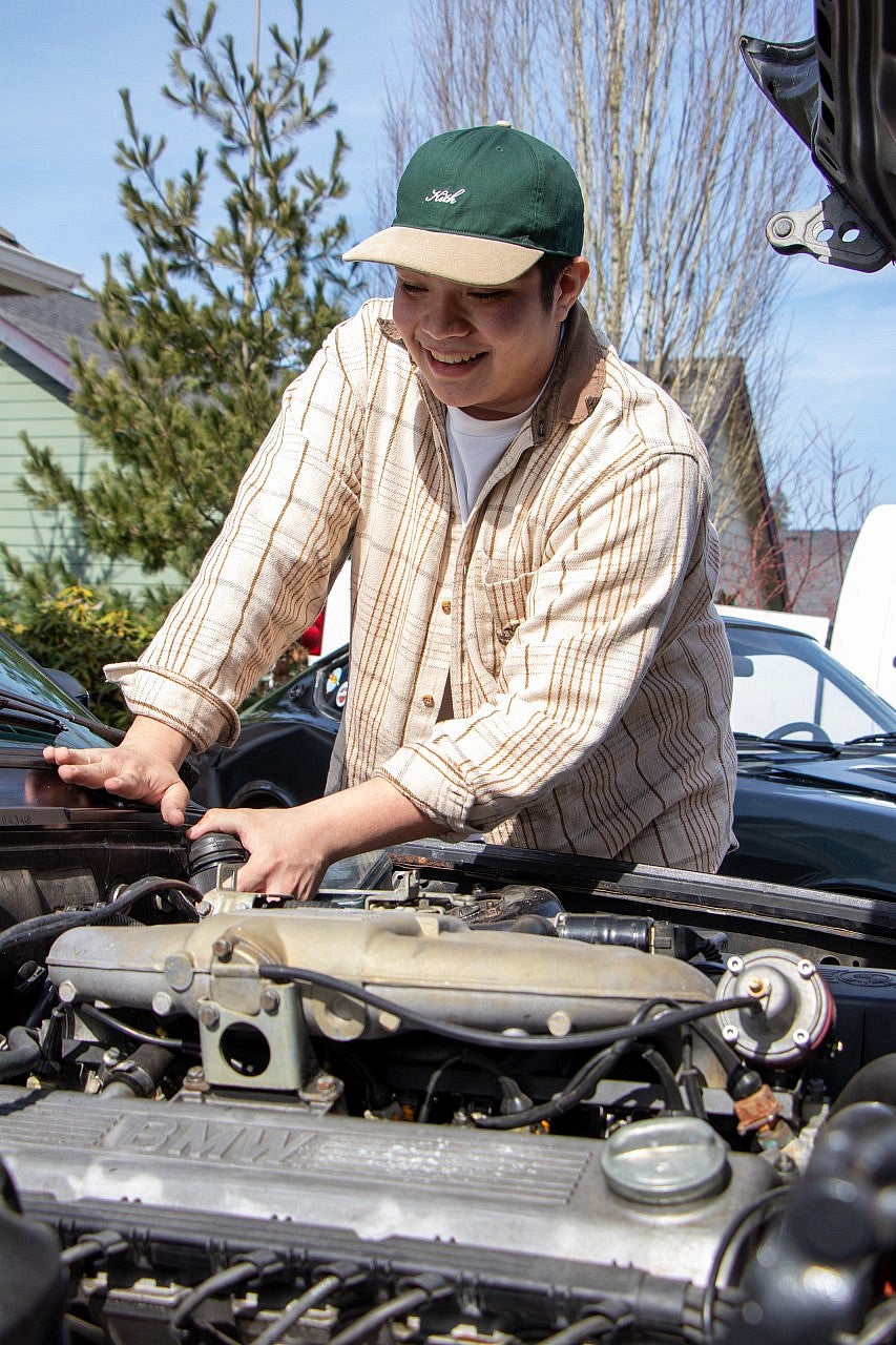 Anthony Cano works on a car's engine.