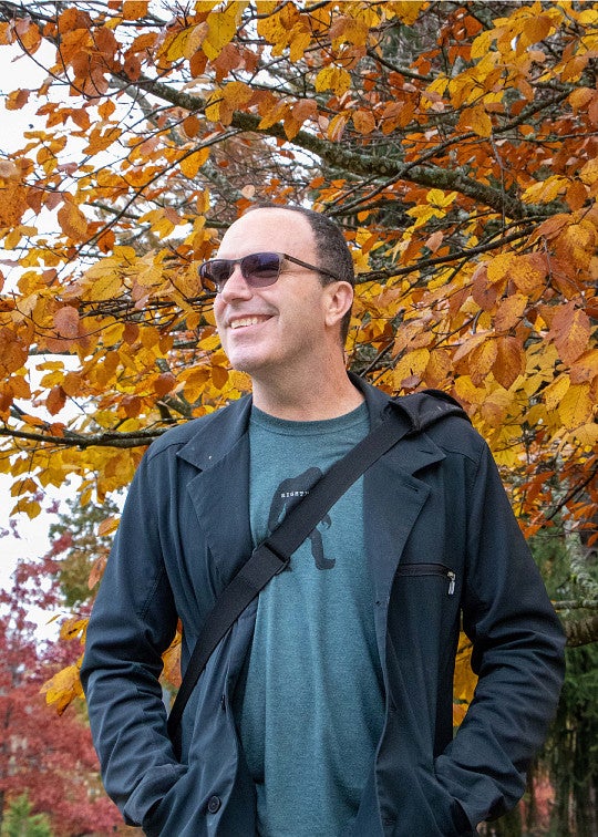 Gantt Gurley underneath a tree with orange and yellow leaves