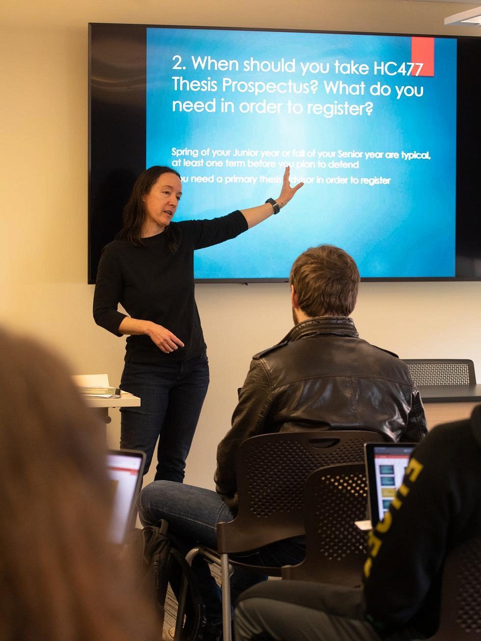 Lisa Munger teaching in front of a digital screen to a room of students