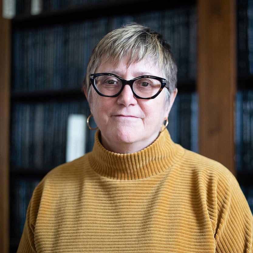 portrait of Carol Stabile in front of thesis shelves