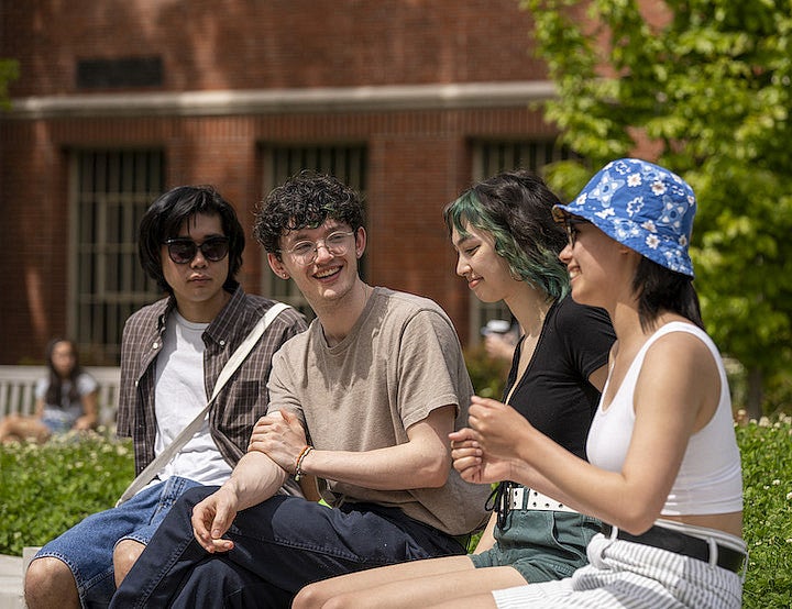 Four students seated outside