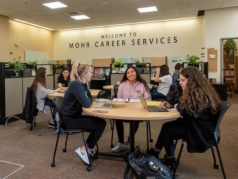 students sitting at a round table underneath a sign reading 'Welcome to Mohr Career Services'
