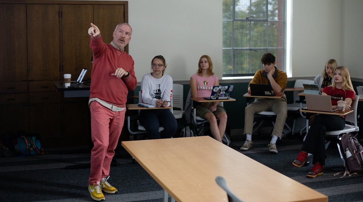 christopher michlig pointing at the board as he teaches a class