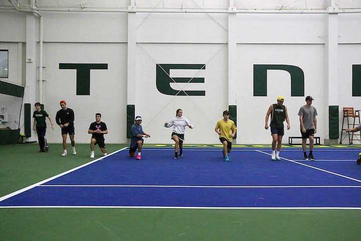 ruby wool doing warmups with tennis players on indoor court