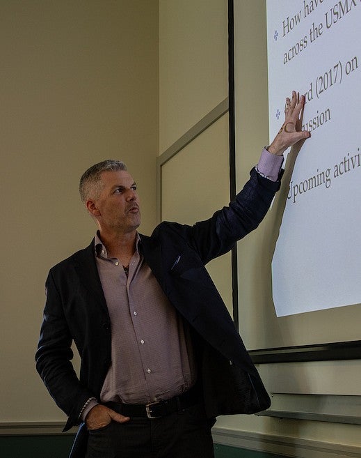 tobin hansen gesturing at a presentation in a classroom