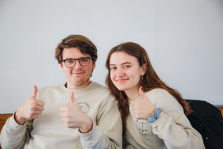 two students in oregon mock trial sweatshirts posing with thumbs up