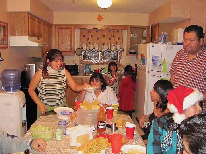 the balbuena family making food around the kitchen table, laughing