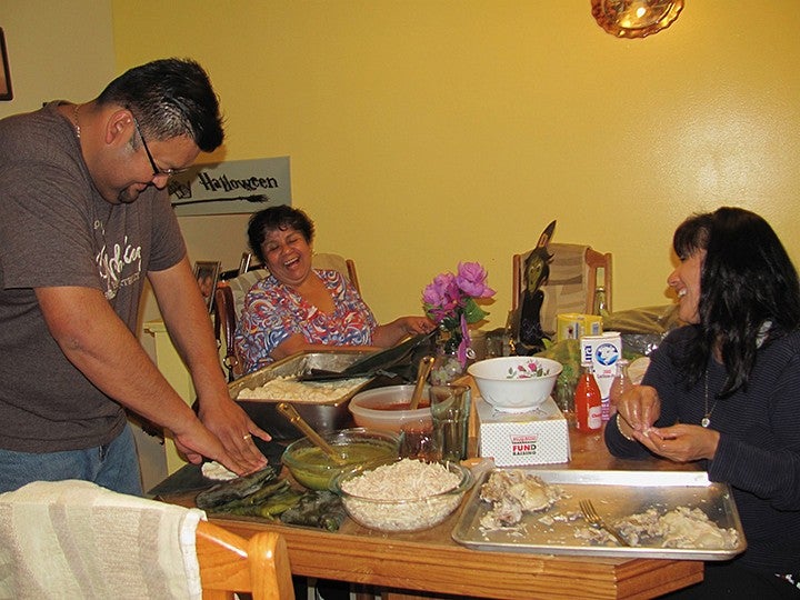 the balbuena family making food around the kitchen table, laughing
