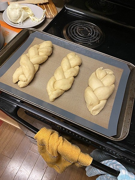 braided dough for dinner rolls in sheetpan sitting on stovetop, waiting to be baked