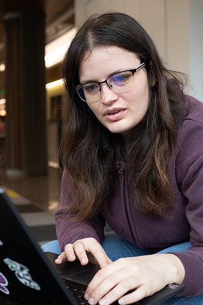 data science student lynette wotruba working on laptop with thoughtful expression