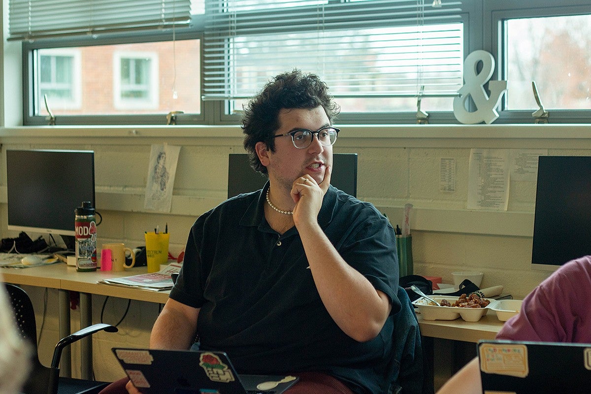 student editor in chief evan reynolds in the daily emerald news meeting, seated, looking thoughtful