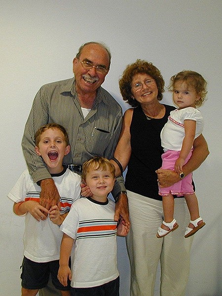 grandparents posing with three grandchildren