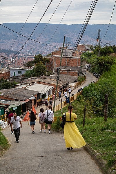 rear view of a group walking down a hill above medellin, colombia, overlooking the city