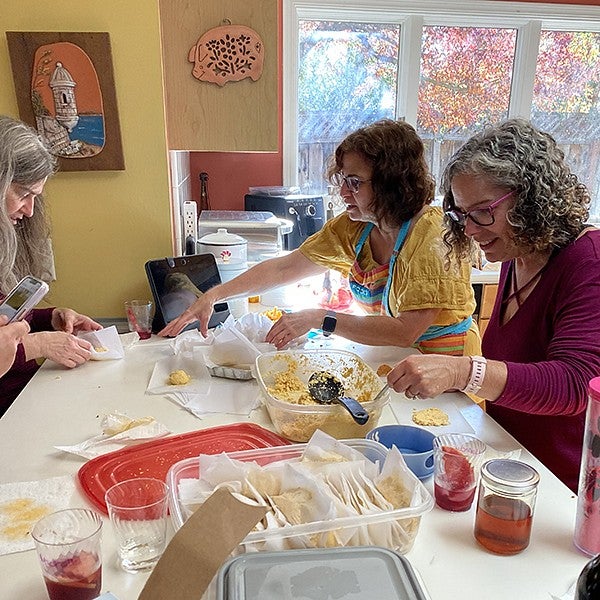 women around table drinking sangria and making alcapurrias