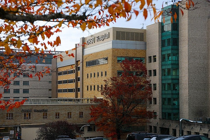 building with "OHSU hospital" written on side, framed by fall foliage