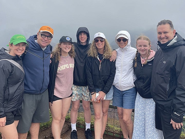 a family posing at a foggy viewpoint dressed in summer jackets