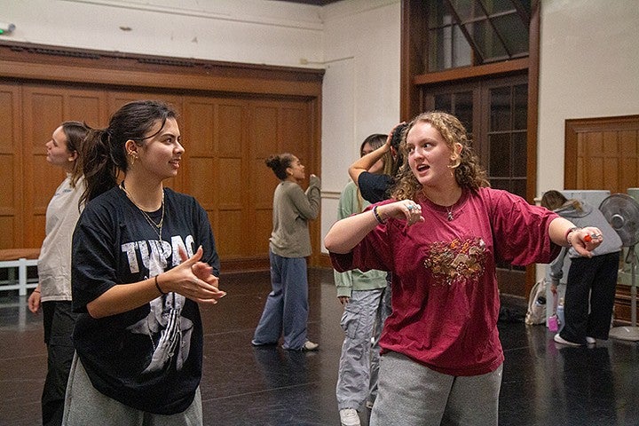 sierra hawes at dance practice, demonstrating a move to another girl