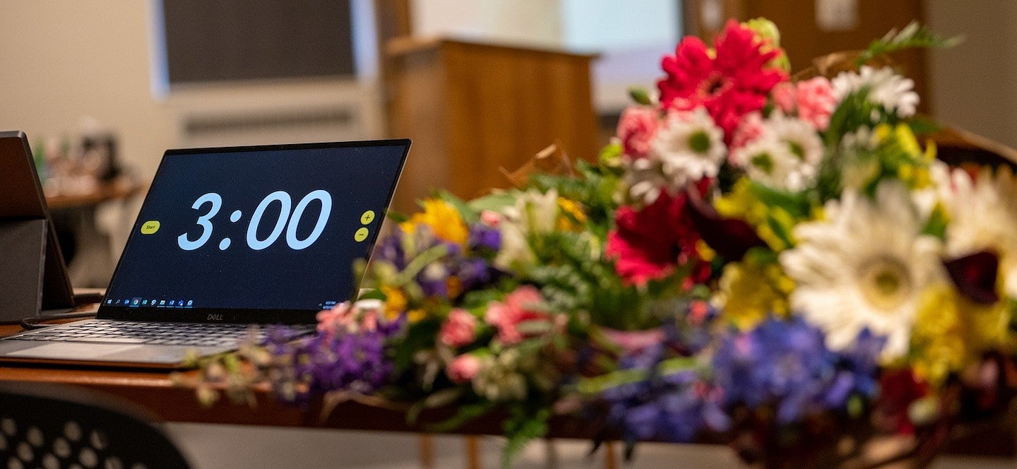 laptop with three-minute countdown timer next to large bouquets on table