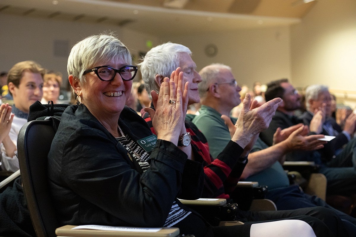 dean carol stabile and audience members applauding at three minute thesis