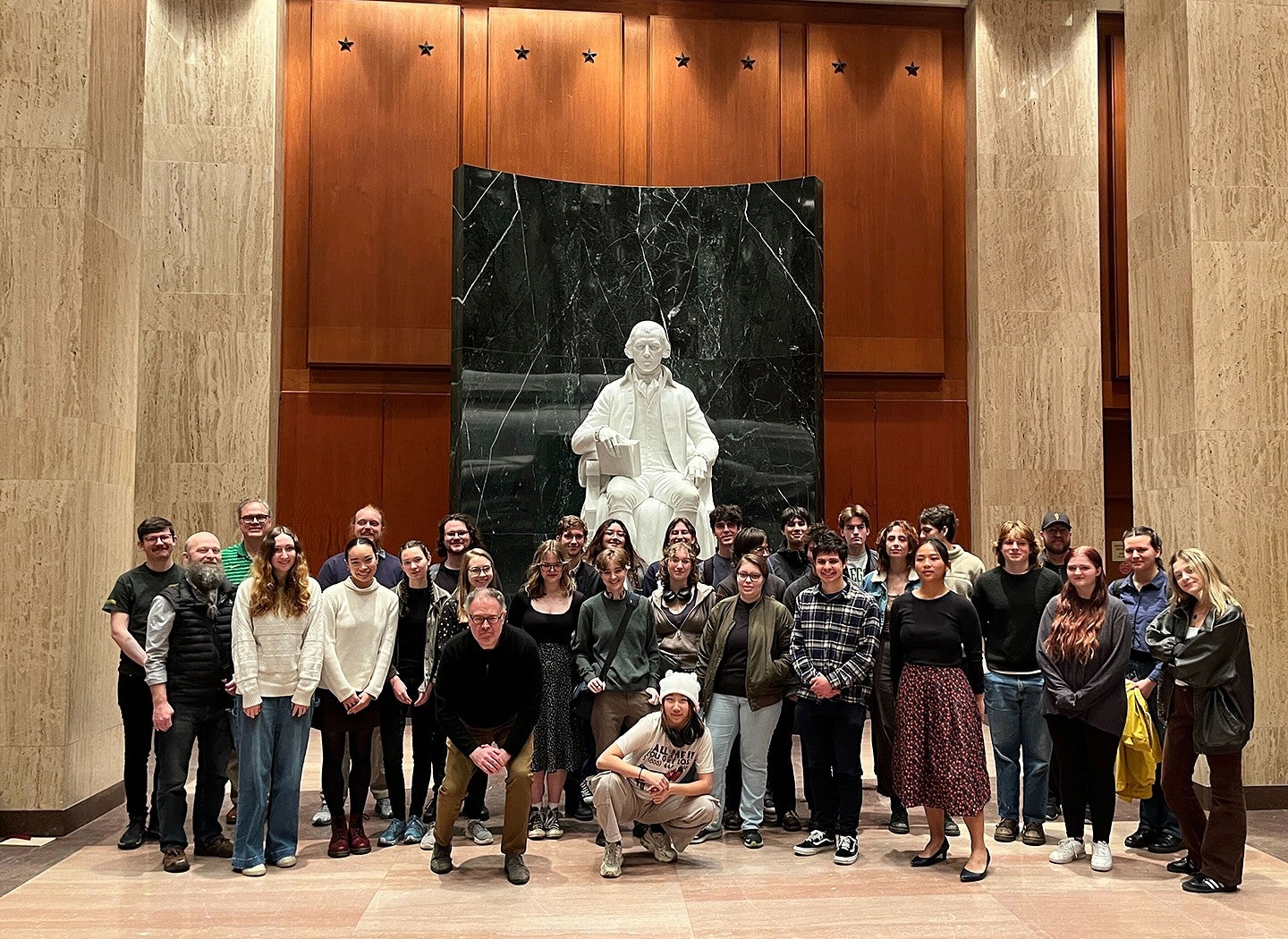 tour group of students posing in front of statue at library of congress