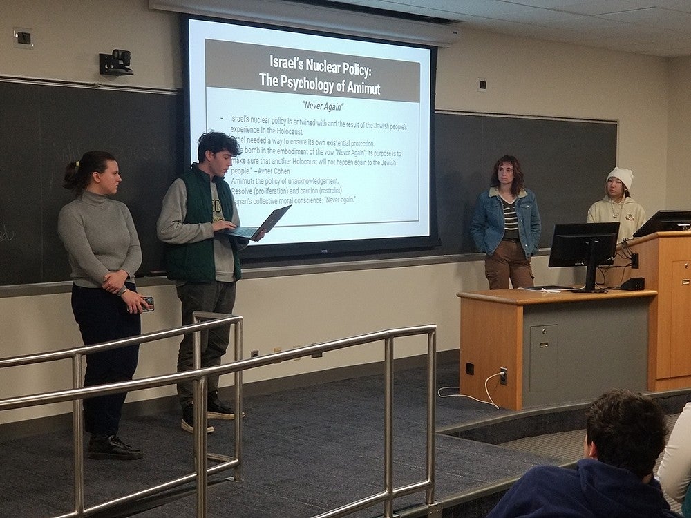 four students presenting powerpoint in classroom