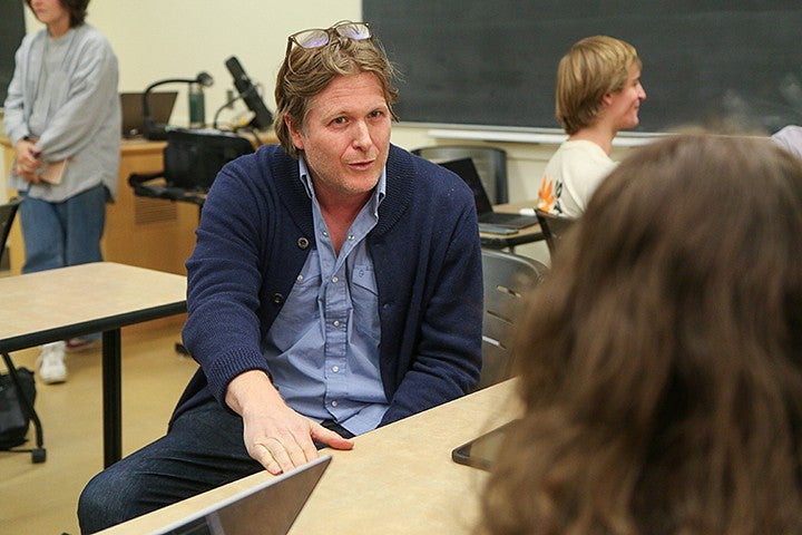 casey shoop talking with a student across a classroom table