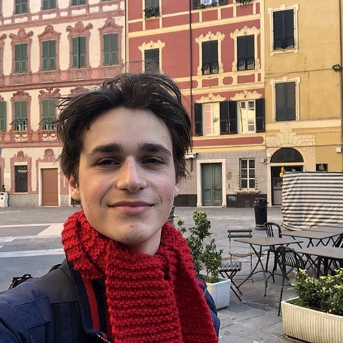 selfie of male student with italian street scene behind him