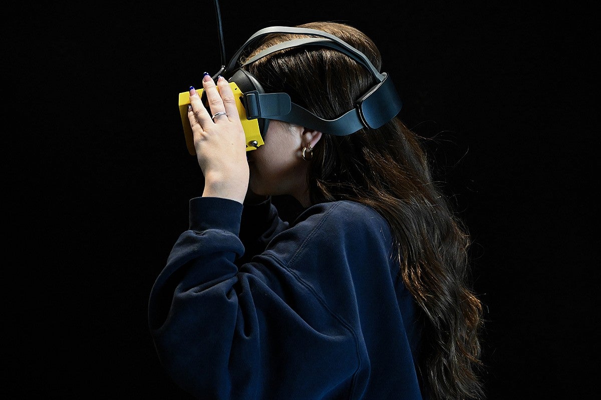 student in vr headset against black background