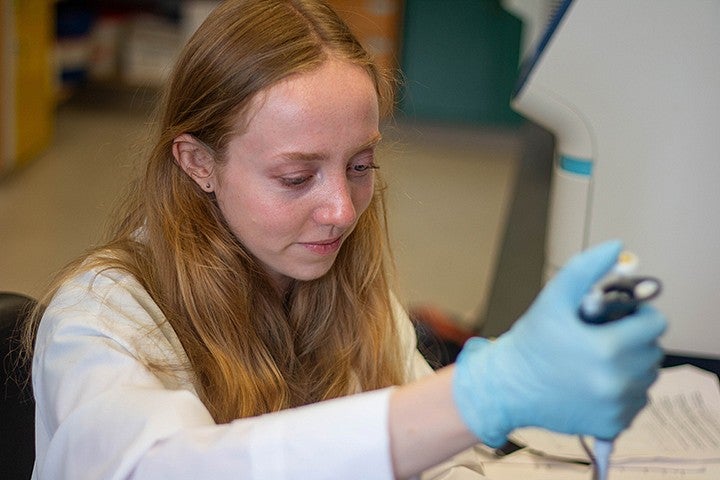 student using pipette in lab