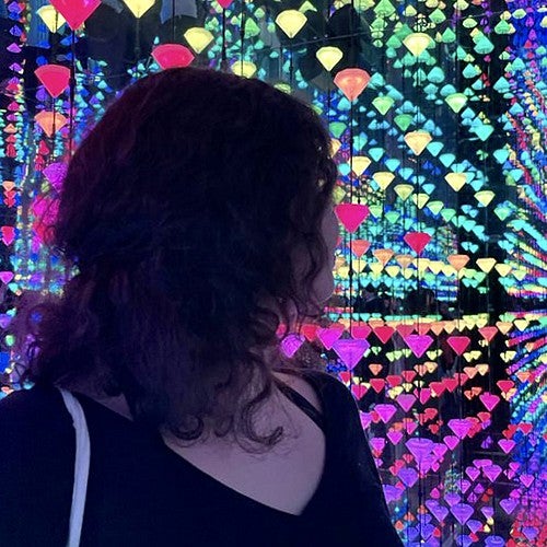 person among hundreds of colorful lights in museum exhibit