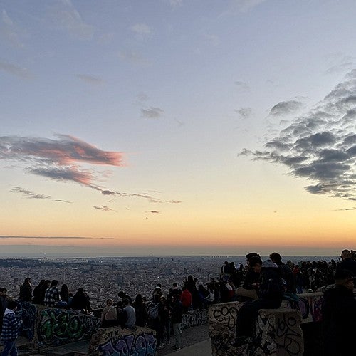 crowd of people overlooking barcelona watching sunset