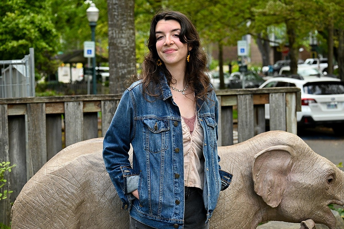 student posing in front of elephant statue