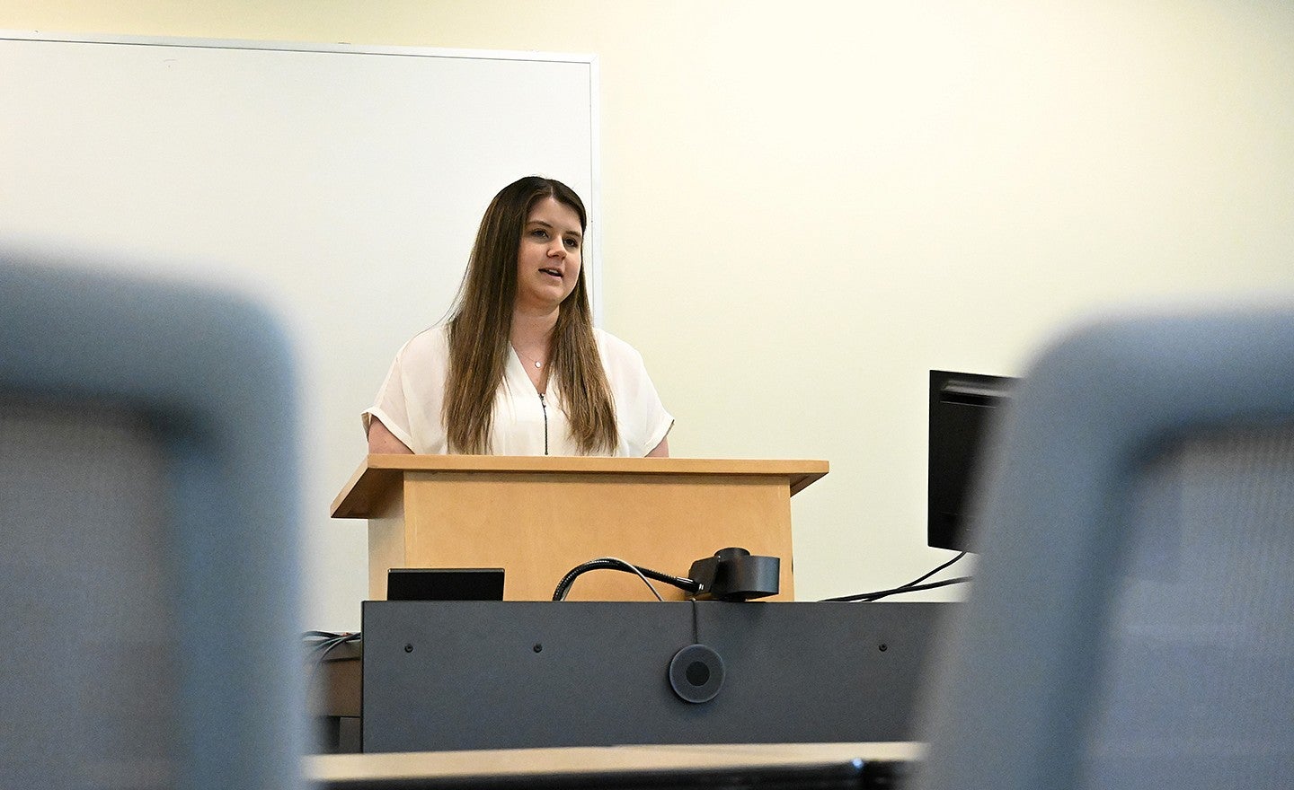 student at podium, speaking to empty classroom