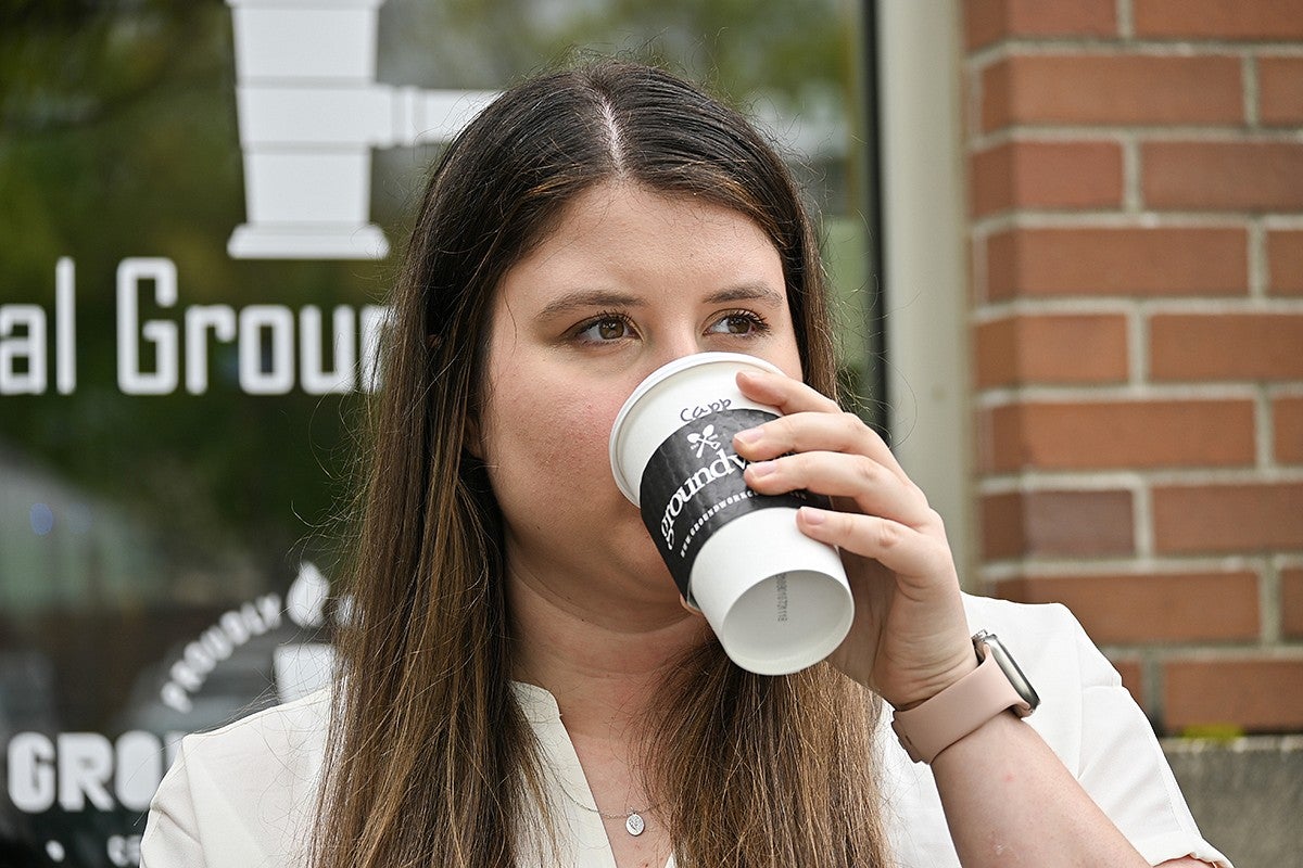 student drinking cappucino sitting outside cafe