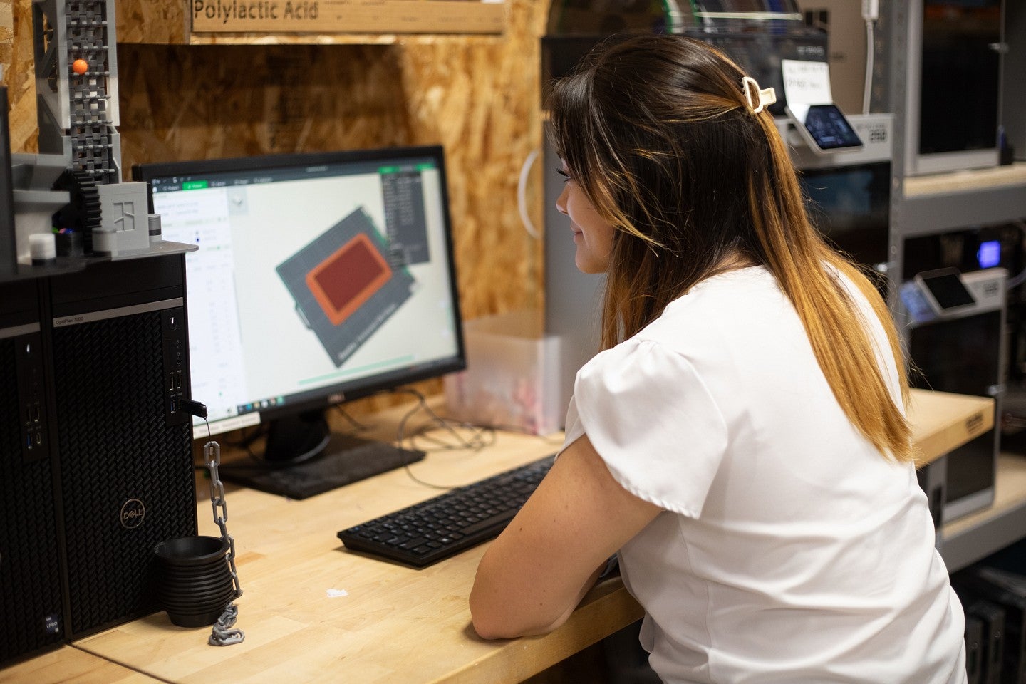 student in design lab at computer, working with graphic models on screen
