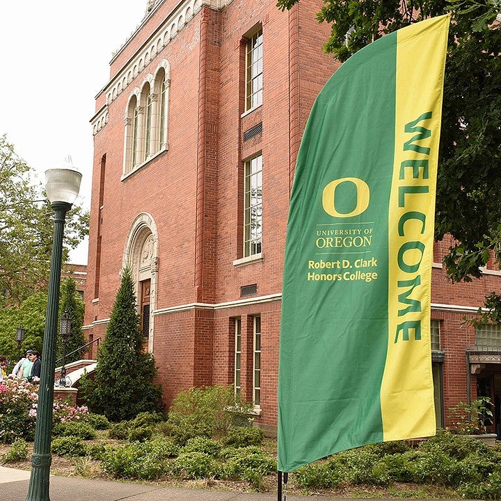 front of Chapman Hall with green and yellow Welcome banner next to building