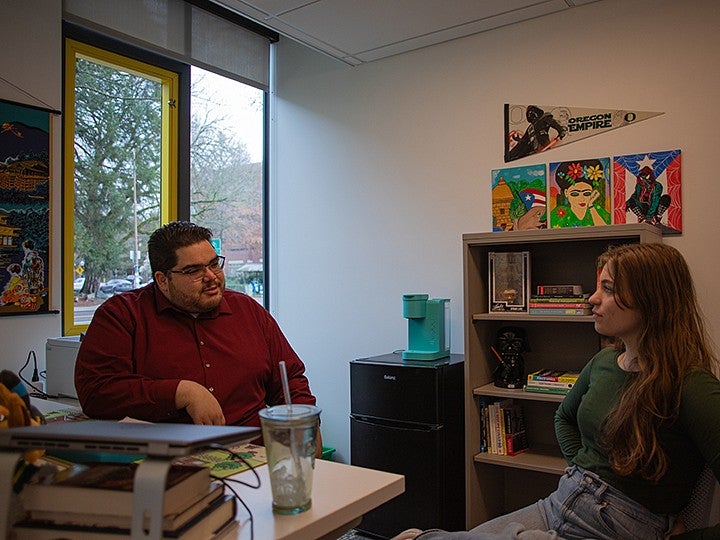 student and advisor sitting in office, talking