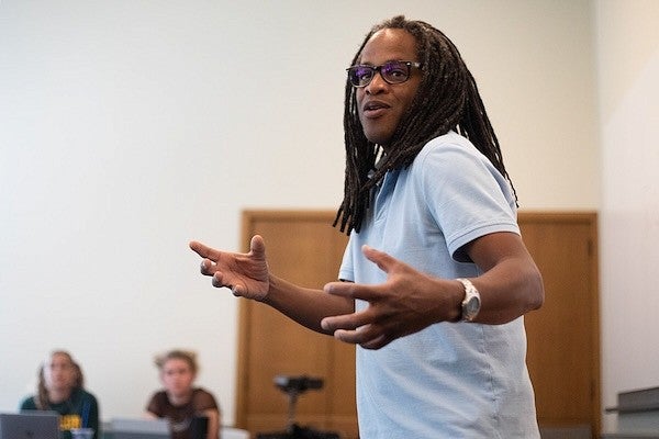 ulrick casimir gesturing while teaching at the front of a classroom