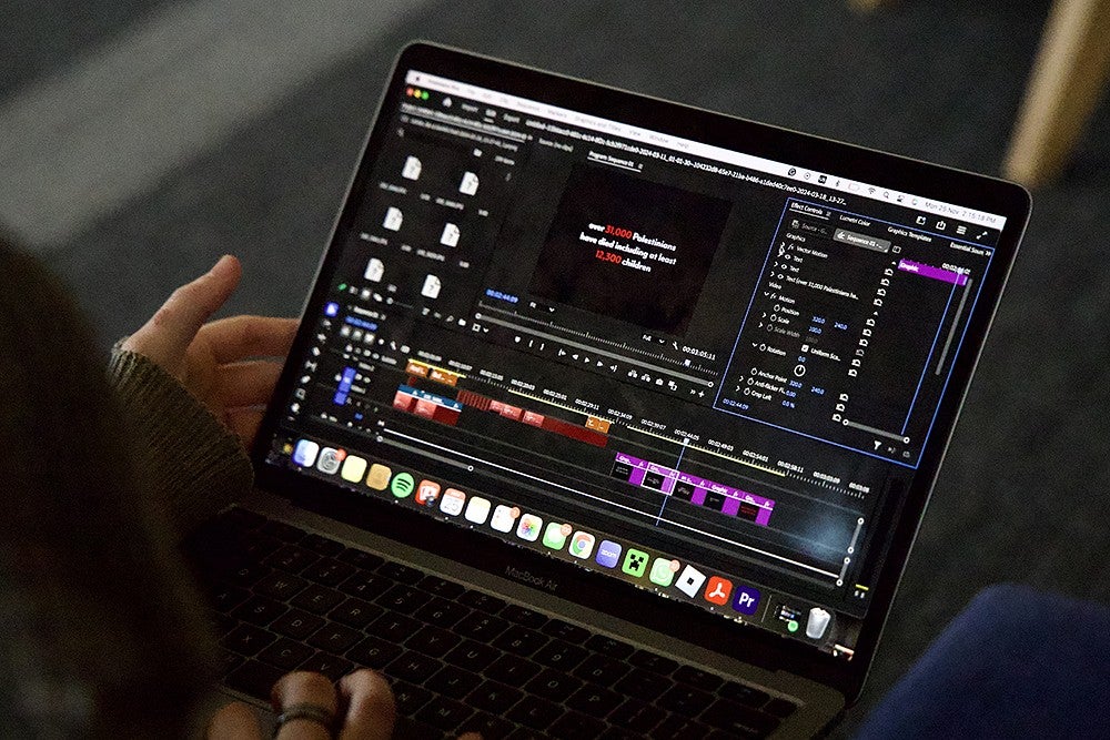 laptop screen showing a video editing program with a statistic about the war in gaza on the preview screen