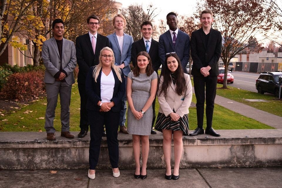 students in UO's mock trial club posing together on campus in formal dress