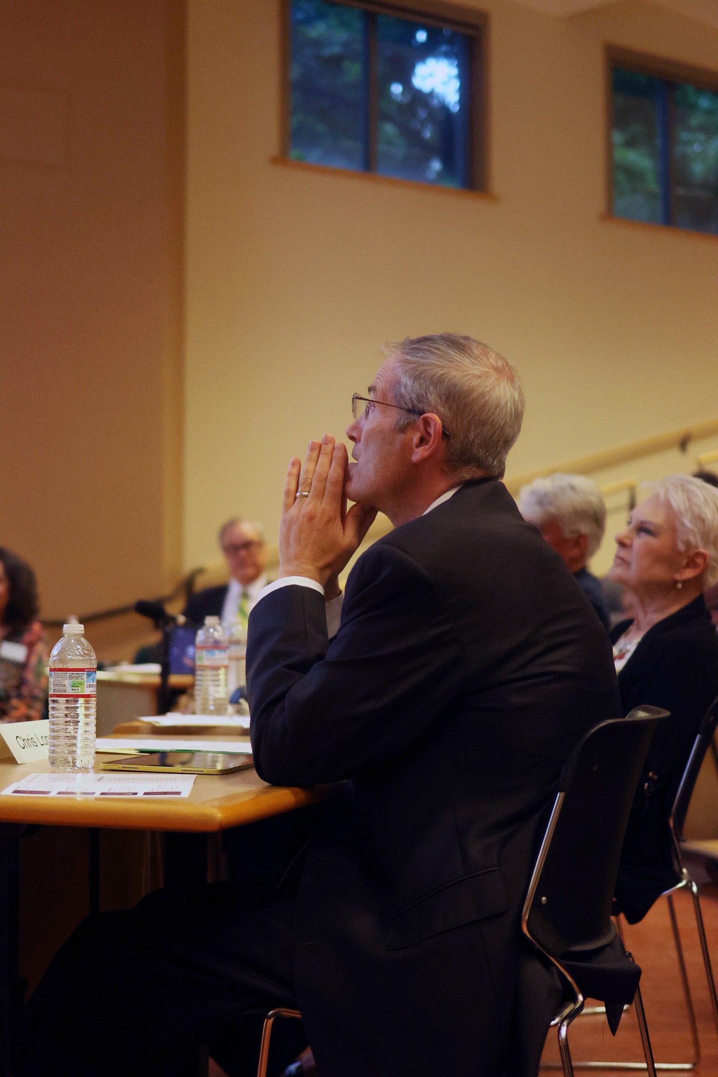 uo provost chris long watching a presentation from the judges table at three minute thesis