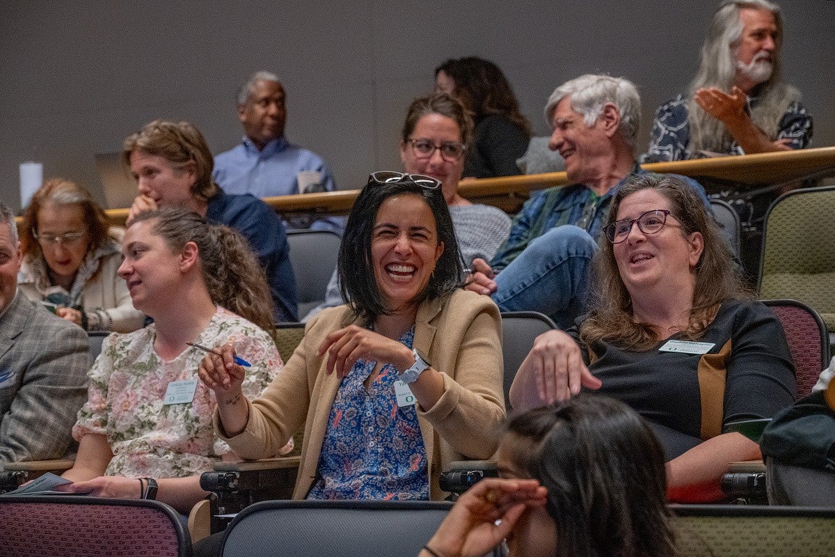 chc faculty members laughing in audience at three minute thesis