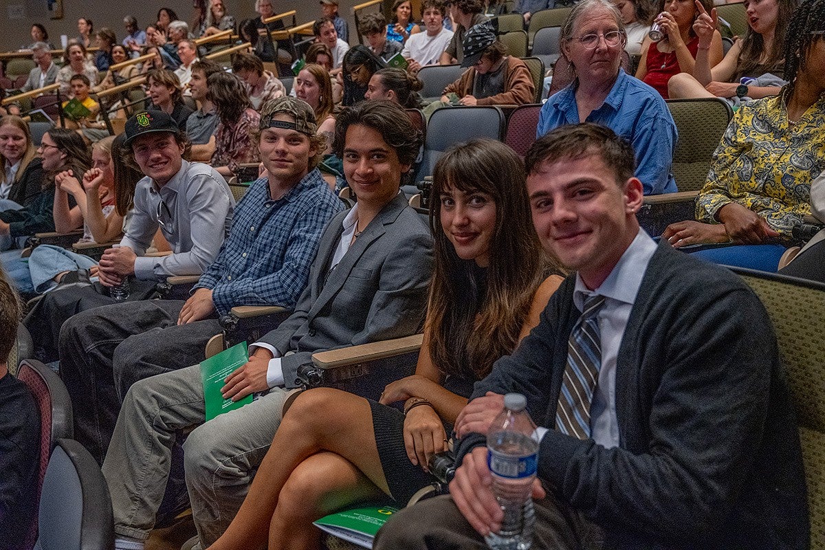 audience members pose with a presenter at three minute thesis