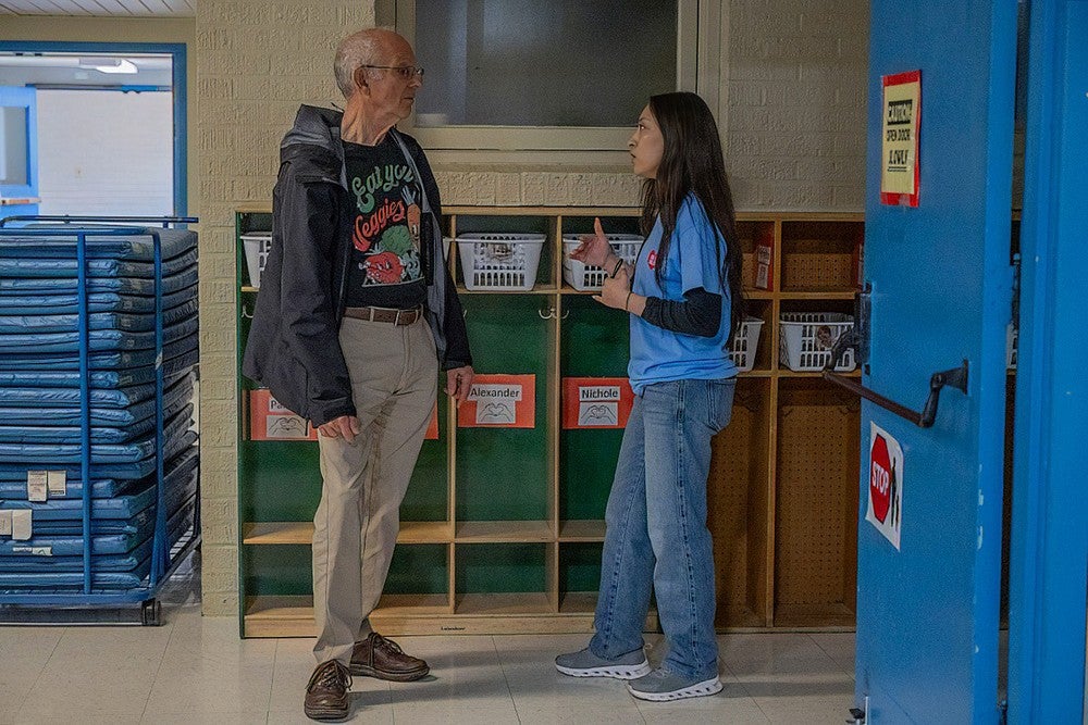 student volunteer talking to community member in a school