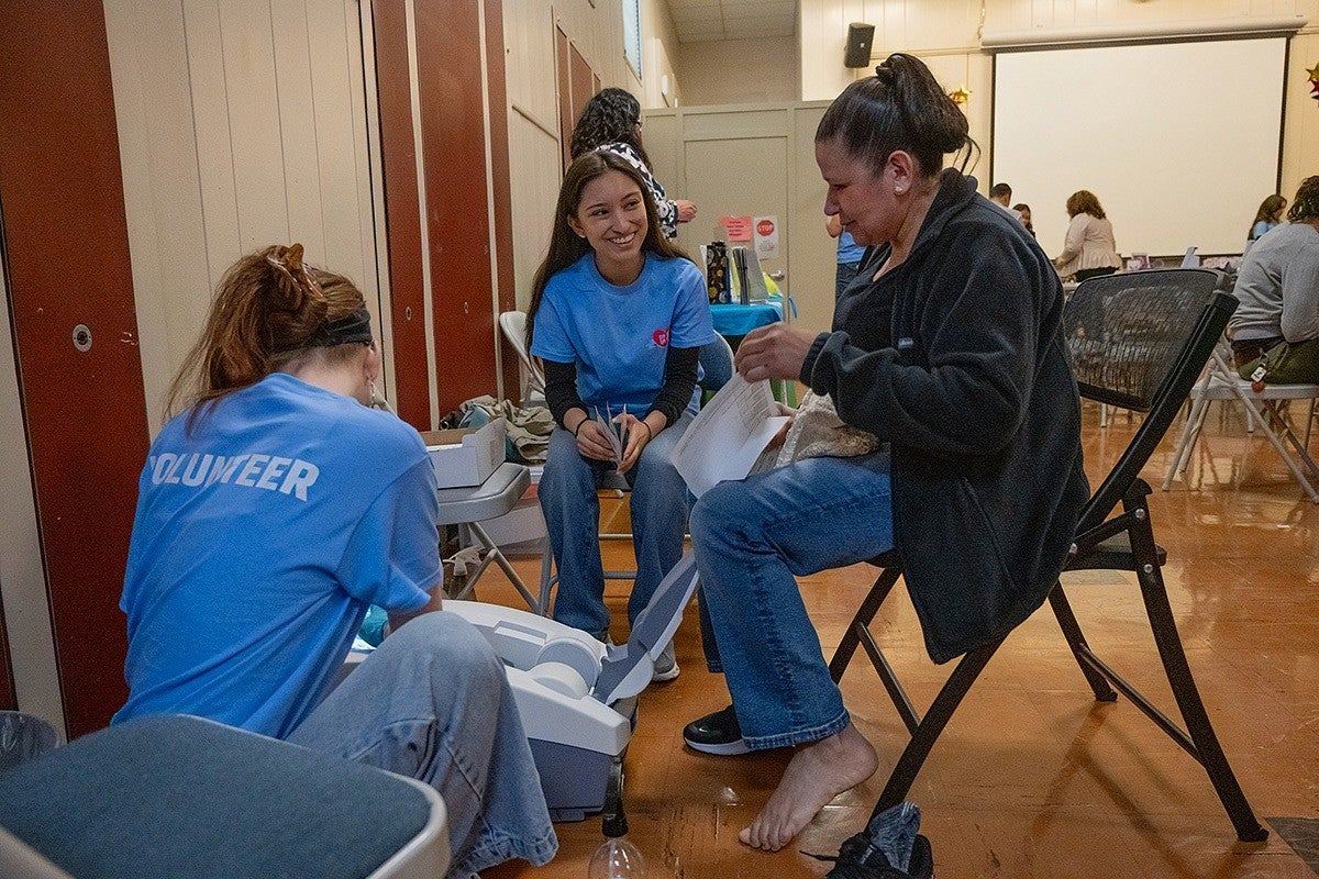 volunteers helping community member with medical device