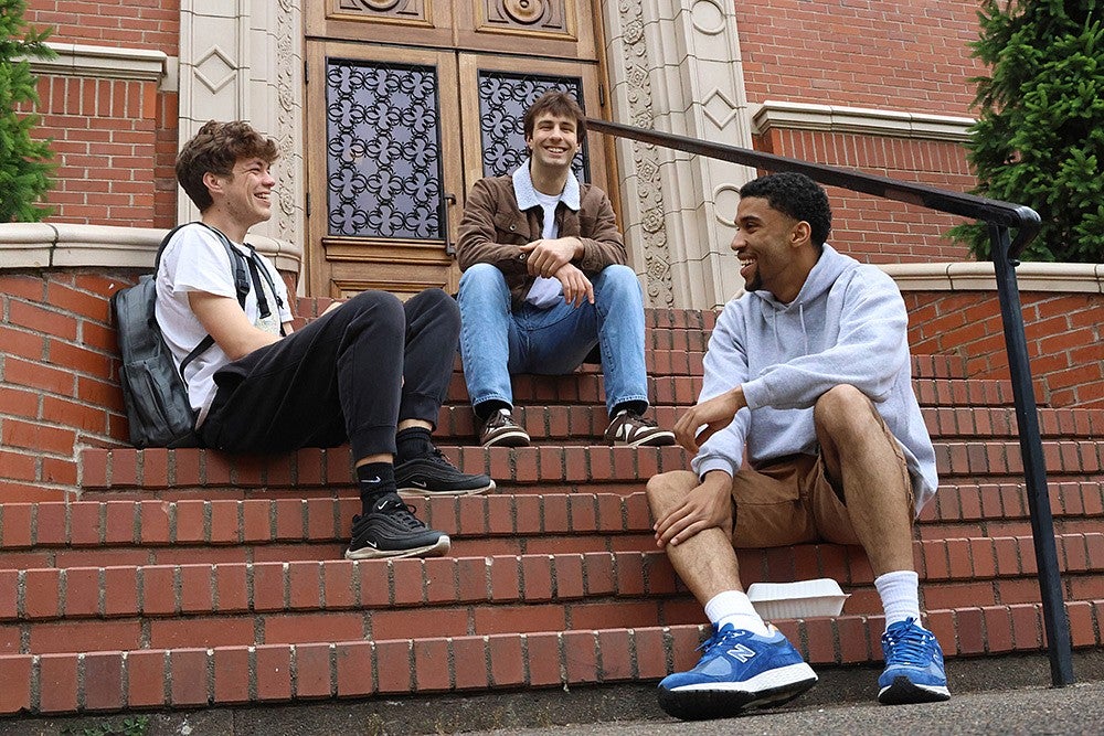 three students hanging out on the steps of chapman hall